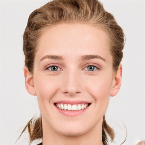 Joyful white young-adult female with short  brown hair and blue eyes