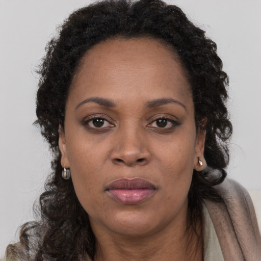 Joyful black adult female with long  brown hair and brown eyes