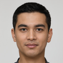 Joyful latino young-adult male with short  black hair and brown eyes