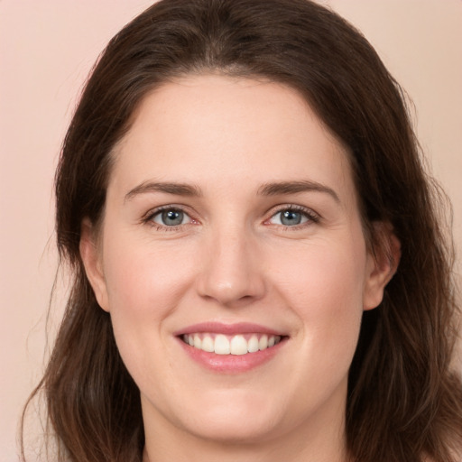 Joyful white young-adult female with long  brown hair and grey eyes