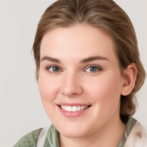 Joyful white young-adult female with medium  brown hair and blue eyes