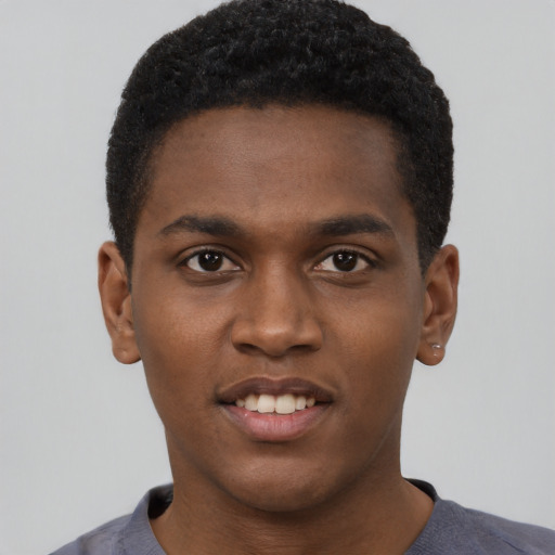 Joyful black young-adult male with short  black hair and brown eyes