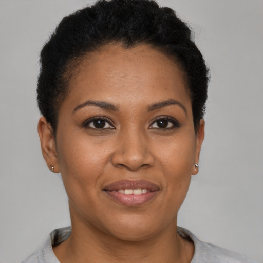 Joyful black young-adult female with short  brown hair and brown eyes