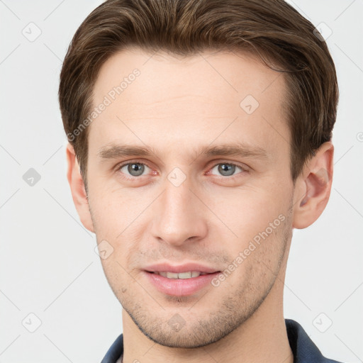 Joyful white young-adult male with short  brown hair and grey eyes