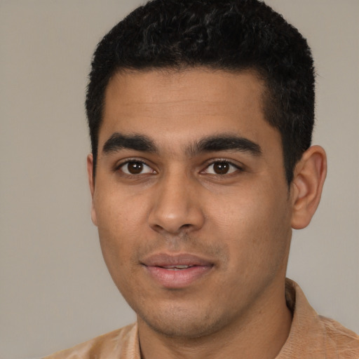 Joyful latino young-adult male with short  black hair and brown eyes