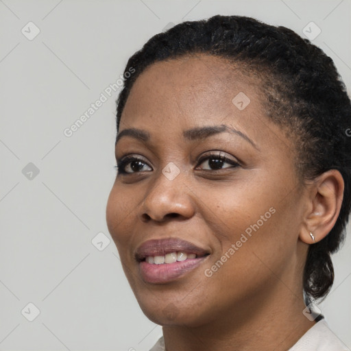 Joyful black young-adult female with short  black hair and brown eyes