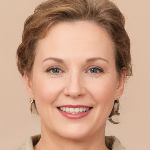 Joyful white adult female with medium  brown hair and grey eyes