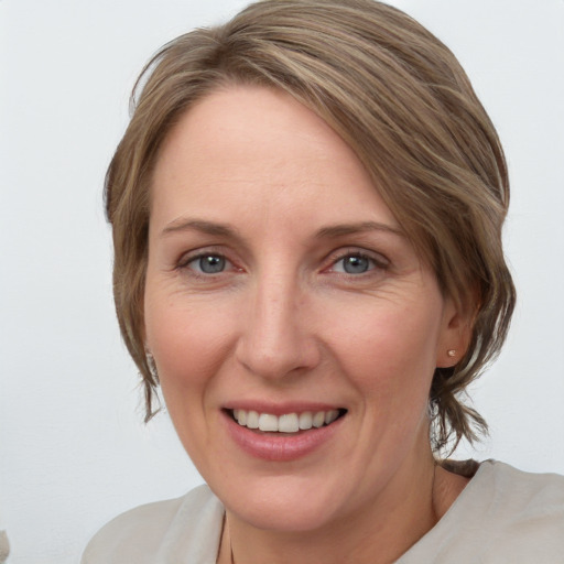 Joyful white adult female with medium  brown hair and grey eyes