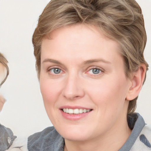 Joyful white young-adult female with medium  brown hair and blue eyes