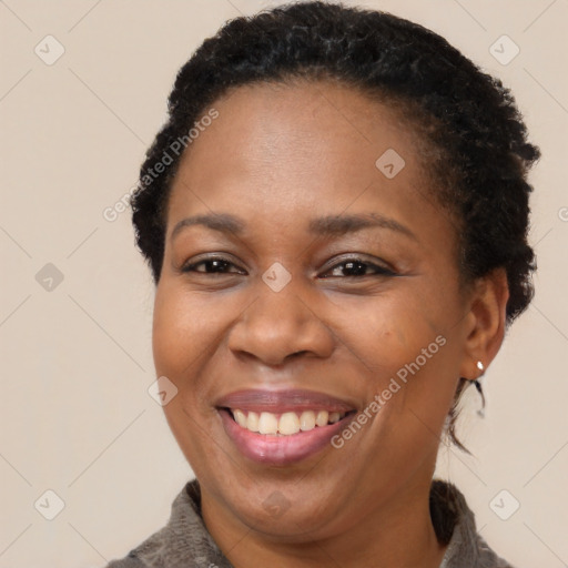 Joyful black adult female with short  brown hair and brown eyes