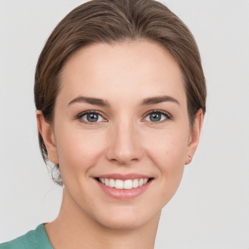 Joyful white young-adult female with medium  brown hair and grey eyes