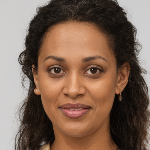 Joyful black adult female with long  brown hair and brown eyes