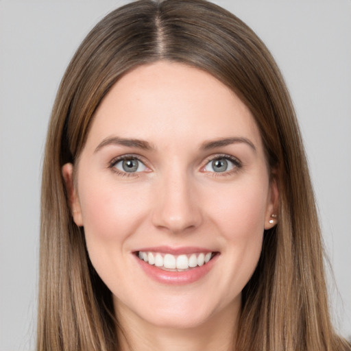 Joyful white young-adult female with long  brown hair and brown eyes