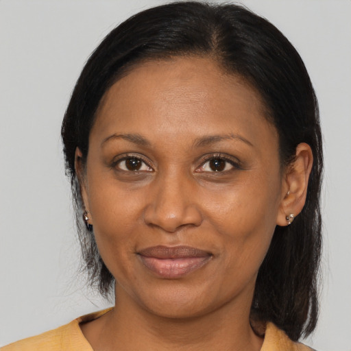 Joyful black adult female with medium  brown hair and brown eyes