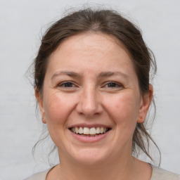 Joyful white adult female with medium  brown hair and brown eyes