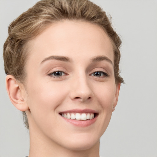 Joyful white young-adult female with short  brown hair and grey eyes