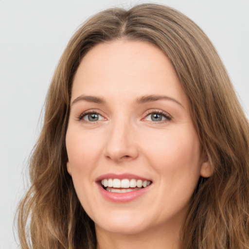 Joyful white young-adult female with long  brown hair and green eyes