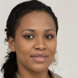 Joyful black young-adult female with long  brown hair and brown eyes