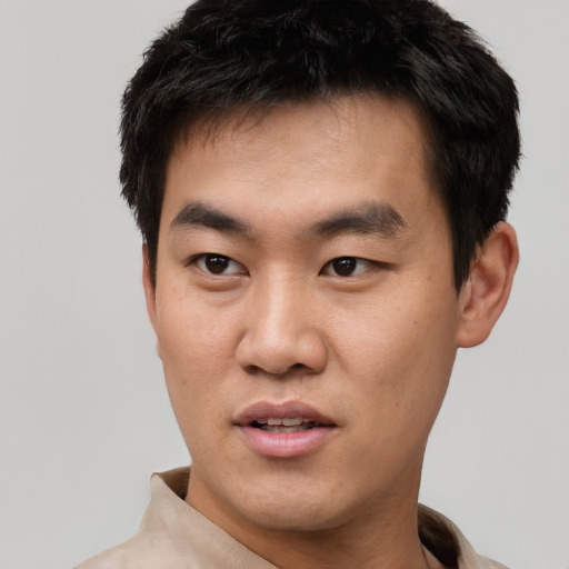Joyful asian young-adult male with short  black hair and brown eyes