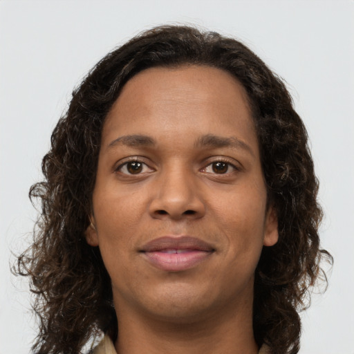 Joyful black young-adult female with long  brown hair and brown eyes