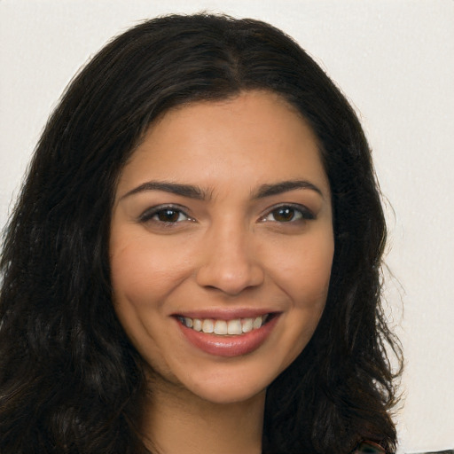 Joyful latino young-adult female with long  brown hair and brown eyes