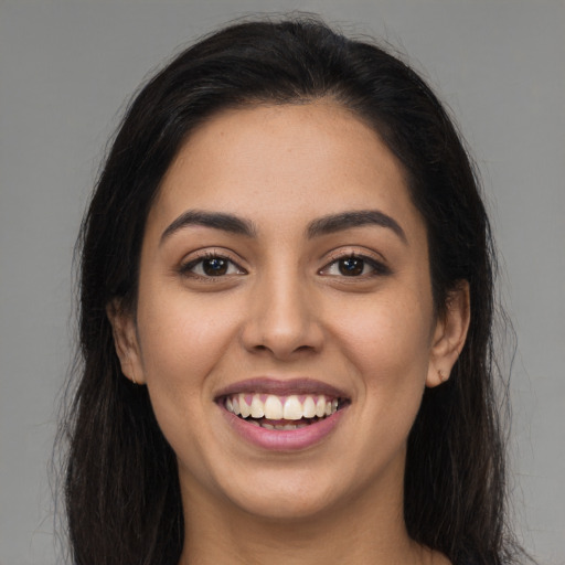 Joyful latino young-adult female with long  brown hair and brown eyes