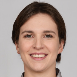 Joyful white young-adult female with medium  brown hair and grey eyes