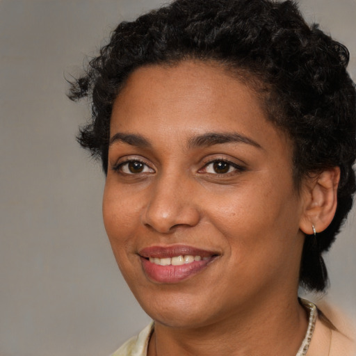Joyful black young-adult female with medium  brown hair and brown eyes