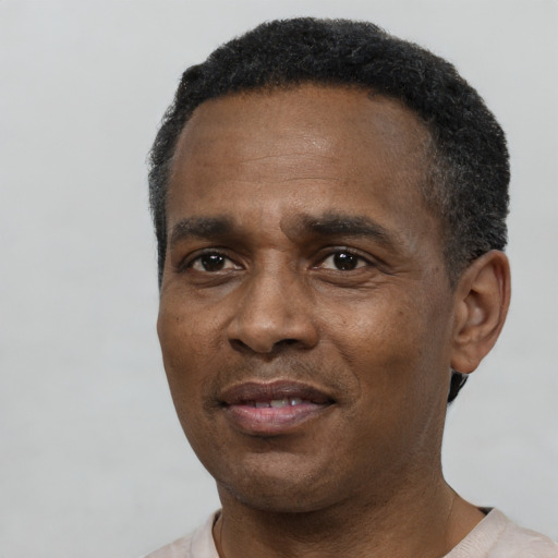 Joyful black adult male with short  black hair and brown eyes