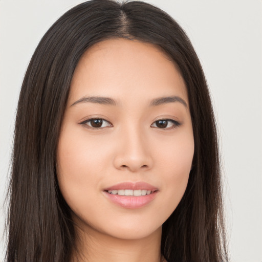 Joyful asian young-adult female with long  brown hair and brown eyes