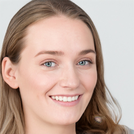 Joyful white young-adult female with long  brown hair and blue eyes