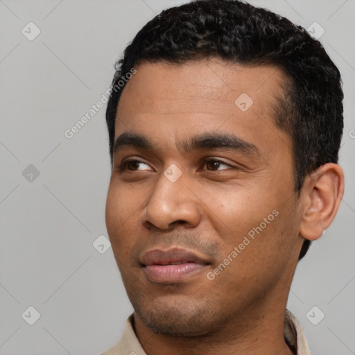 Joyful latino young-adult male with short  black hair and brown eyes