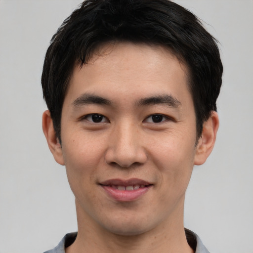 Joyful asian young-adult male with short  black hair and brown eyes
