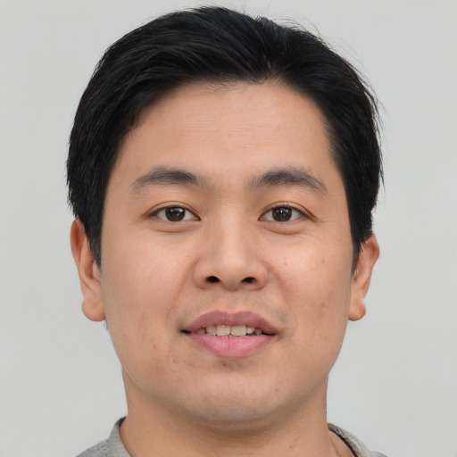 Joyful asian young-adult male with short  brown hair and brown eyes