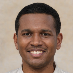 Joyful latino young-adult male with short  brown hair and brown eyes