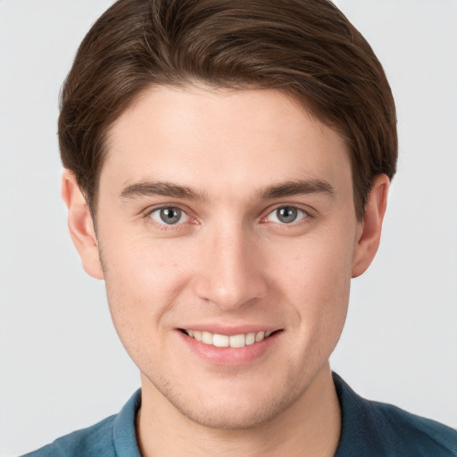 Joyful white young-adult male with short  brown hair and grey eyes