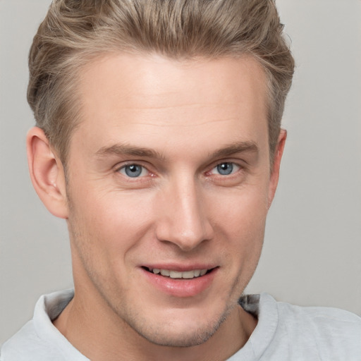 Joyful white young-adult male with short  brown hair and grey eyes