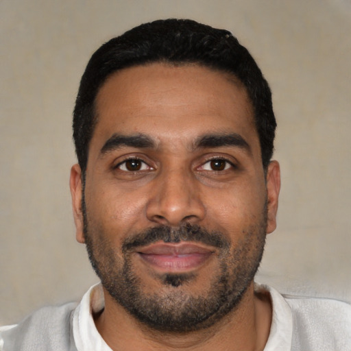 Joyful black young-adult male with short  black hair and brown eyes