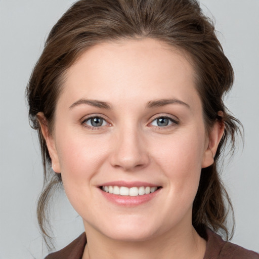 Joyful white young-adult female with medium  brown hair and grey eyes