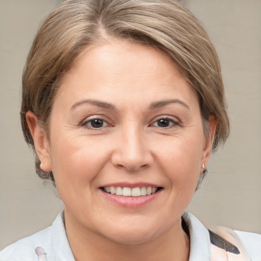 Joyful white adult female with medium  brown hair and grey eyes