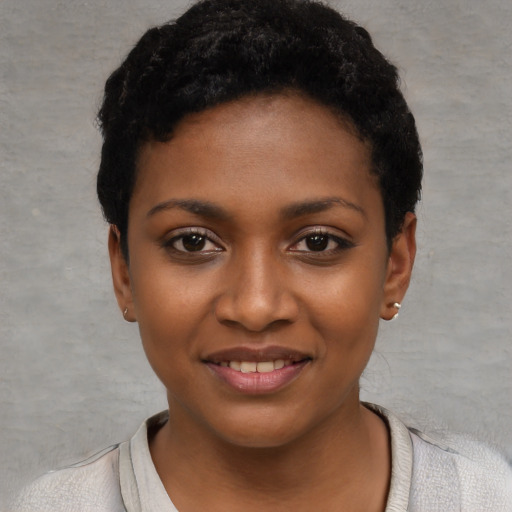 Joyful black young-adult female with short  black hair and brown eyes