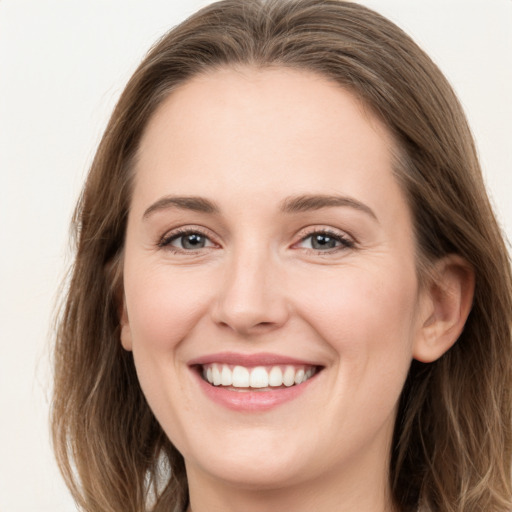 Joyful white young-adult female with long  brown hair and grey eyes