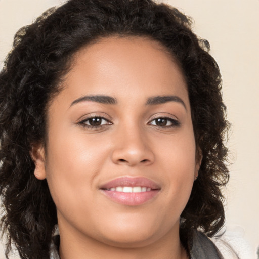 Joyful latino young-adult female with long  brown hair and brown eyes