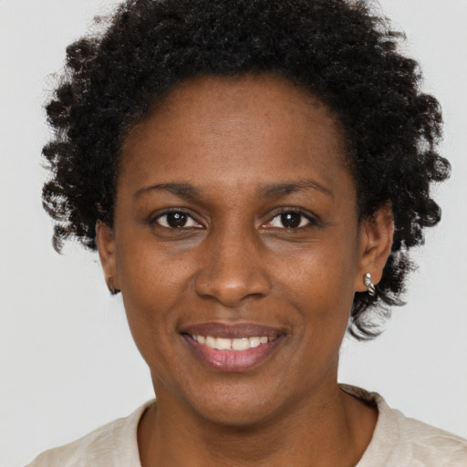 Joyful black adult female with short  brown hair and brown eyes