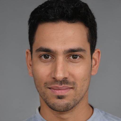 Joyful white young-adult male with short  black hair and brown eyes