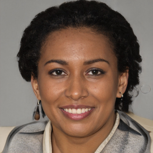 Joyful black young-adult female with short  brown hair and brown eyes