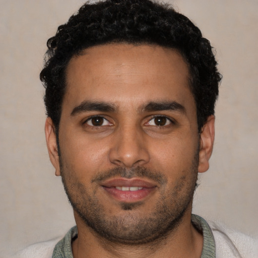Joyful black young-adult male with short  black hair and brown eyes