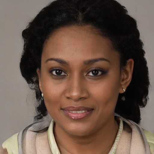 Joyful black young-adult female with long  brown hair and brown eyes