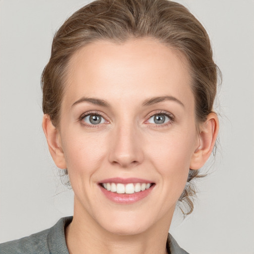 Joyful white young-adult female with medium  brown hair and grey eyes