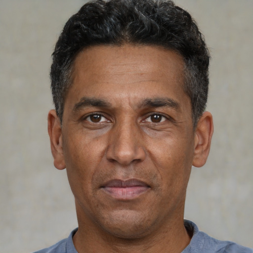 Joyful black adult male with short  black hair and brown eyes